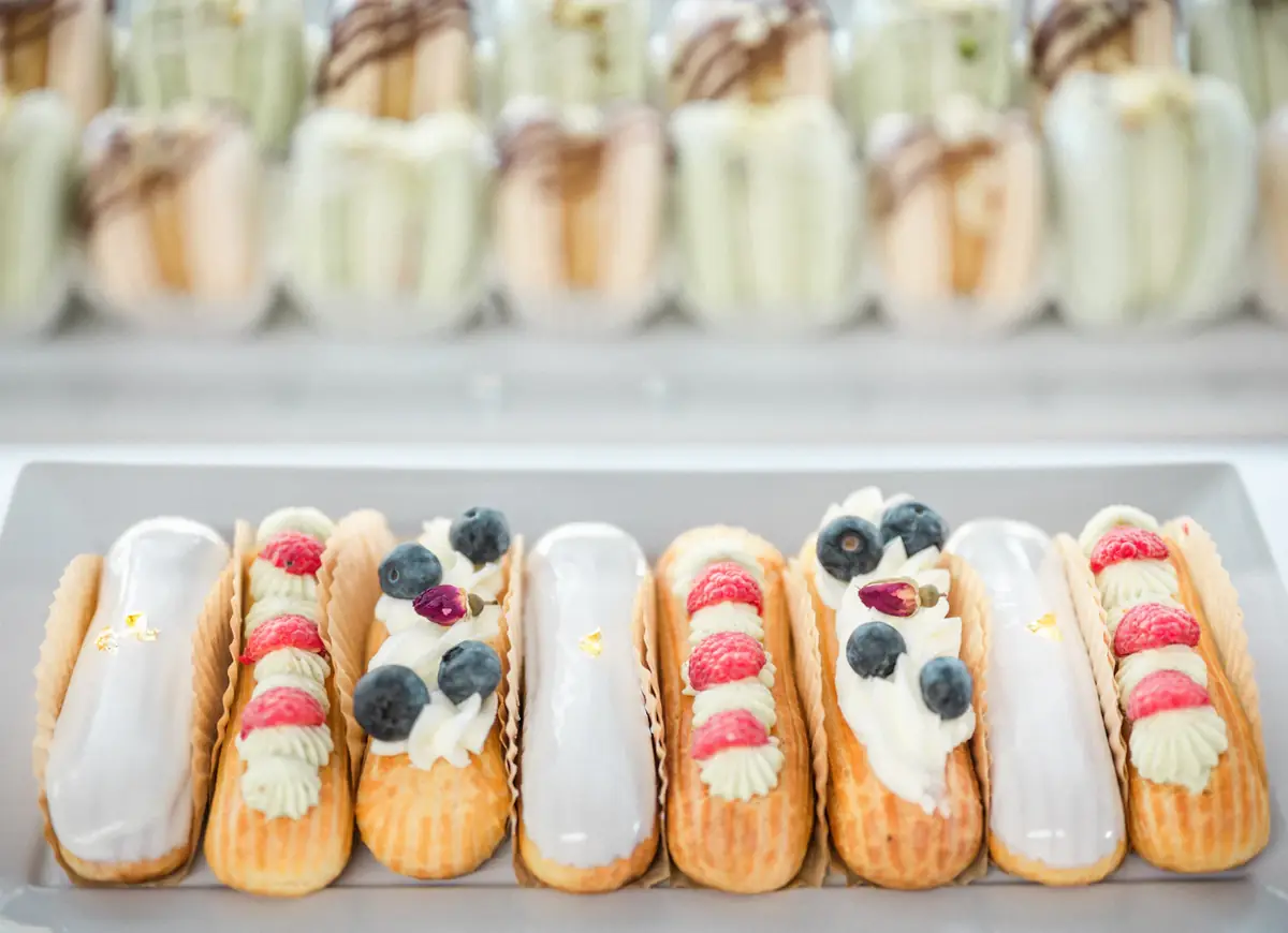 Rij afgewerkte éclairs met room en vers fruit
